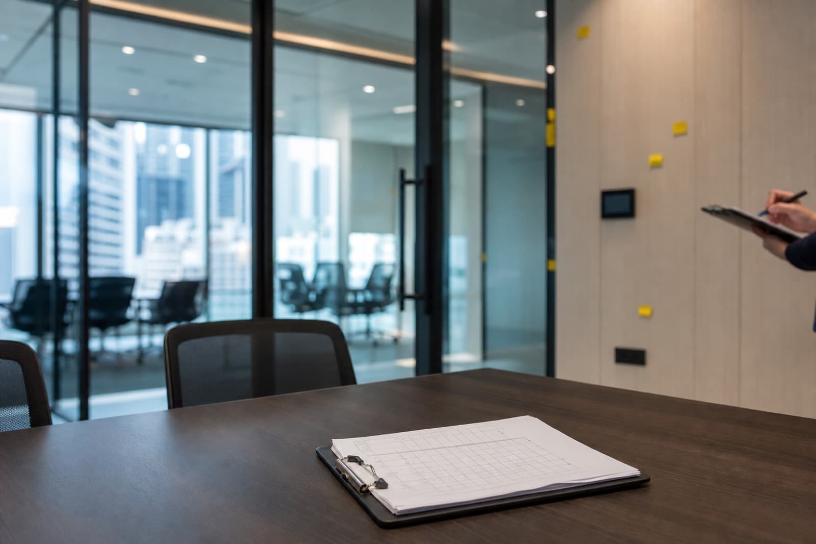 Singapore office fit-out snagging inspection with checklist on a conference table in a finished glass meeting room