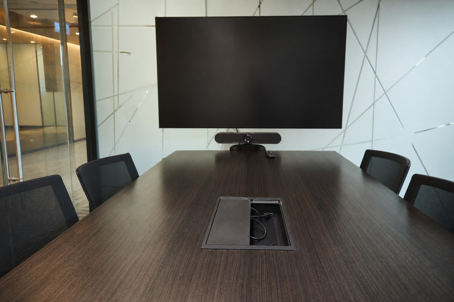 Conference table cable cubby and wall display in a Singapore meeting room