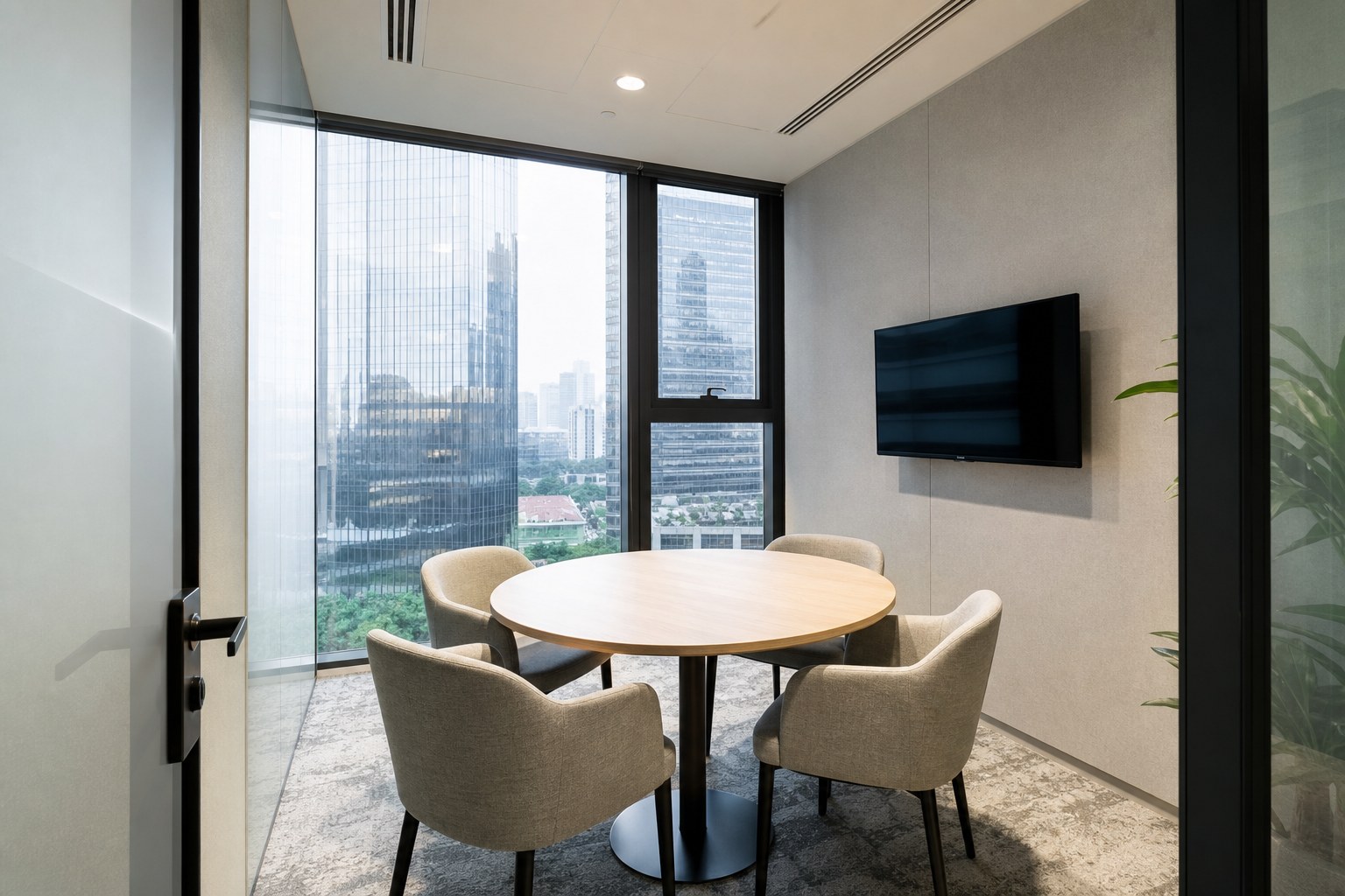 Small glass huddle room with round table for four in a Singapore office